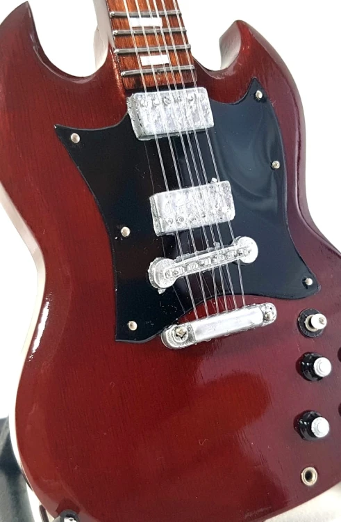 Ręcznie wykonana gitara z drewna mahoniowego ma około 27,5 cm wysokości i nawiązuje do scenicznego stylu Angus Younga.