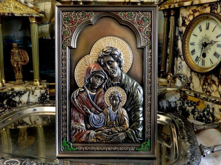 Barwna płaskorzeźba Świętej Rodziny z dekoracyjnymi aureolami i ornamentami.