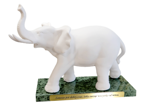 Biały porcelanowy słoń z uniesioną trąbą i marmurową podstawą, elegancka dekoracja salonu lub gabinetu.