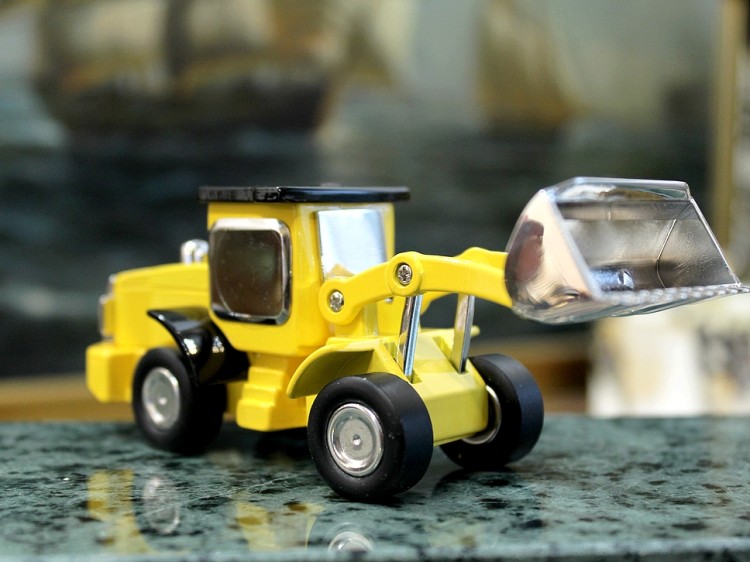 Zegar w mini ładowarce kołowej, dekoracja półki warsztatu mechanika.