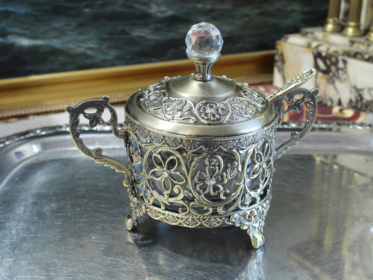 Metalowa cukiernica z uchwytami i szklanym wkładem dla eleganckiej gospodyni domu
