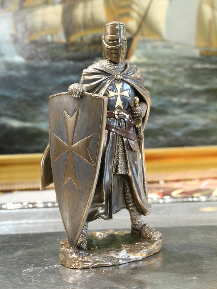 Statuetka rycerza maltańskiego z mieczem przy pasie i tarczą opartą o ziemię