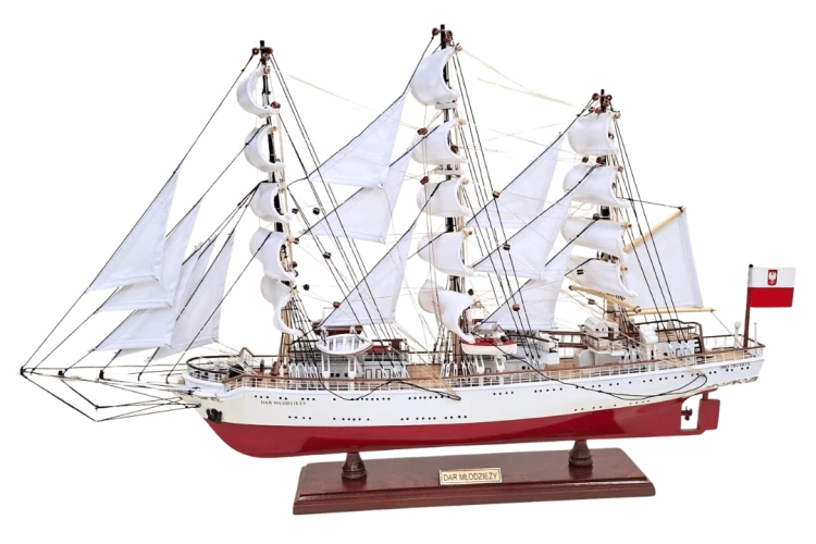 Model żaglowca Dar Młodzieży z białymi żaglami i drewnianą podstawą, prezentujący proporcje 71 × 16 × 45 cm