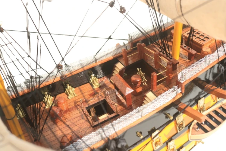 Model żaglowca HMS Victory z rzędami dział, kotwicą i detalami charakterystycznych czarno-żółtych burt
